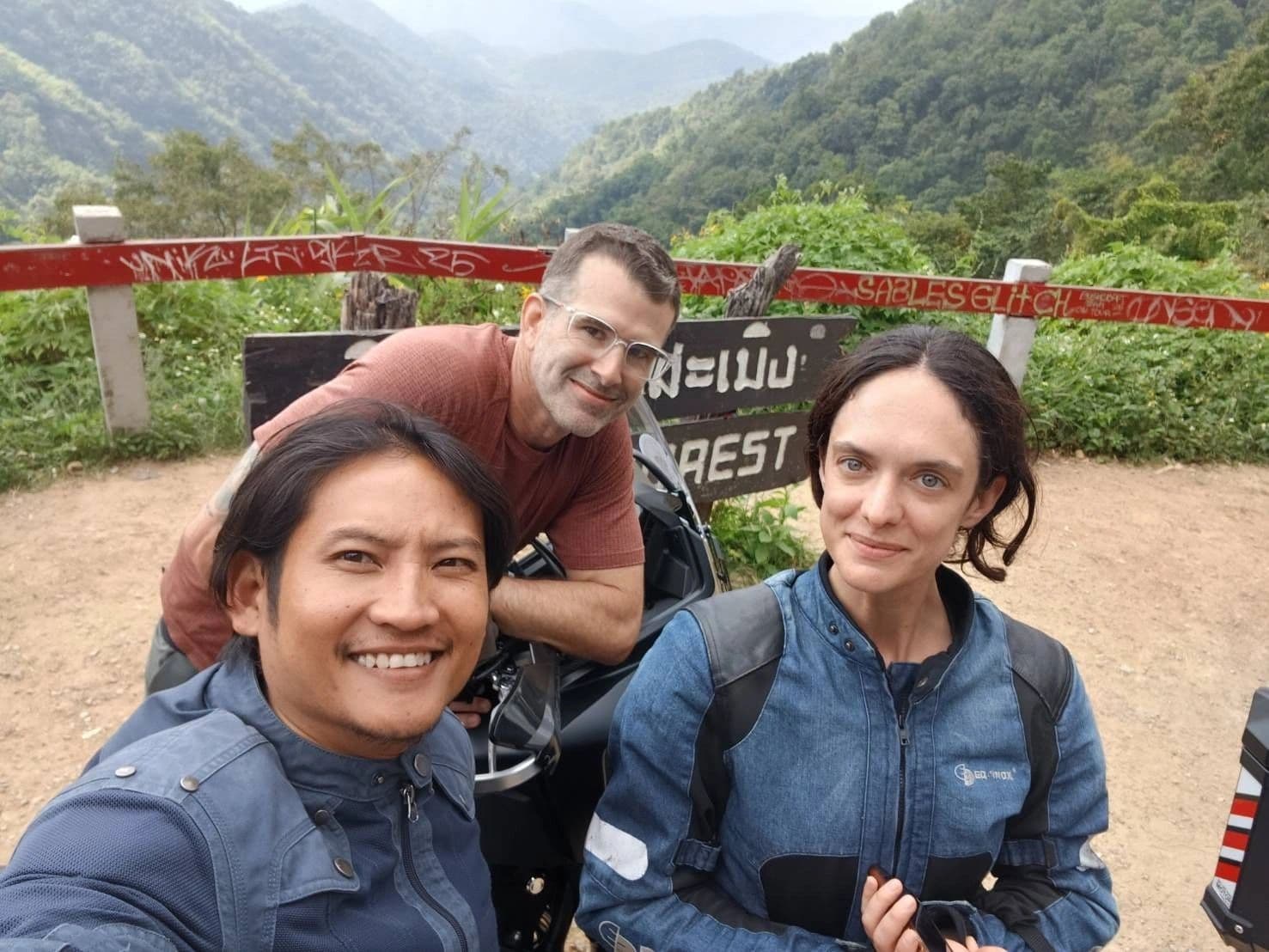 Guide and riders at a mountain viewpoint