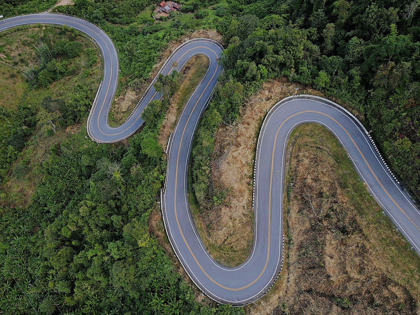 Switchbacks stacked down a forested ridge on the Mae Hong Son Loop